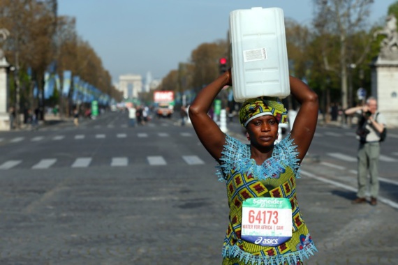 Marathon de Paris : une Gambienne au départ avec un bidon d'eau sur la tête