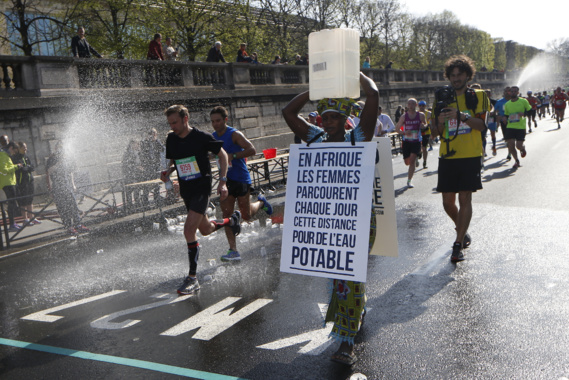 Marathon de Paris : une Gambienne au départ avec un bidon d'eau sur la tête